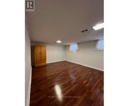A room with wooden flooring and a wooden door.