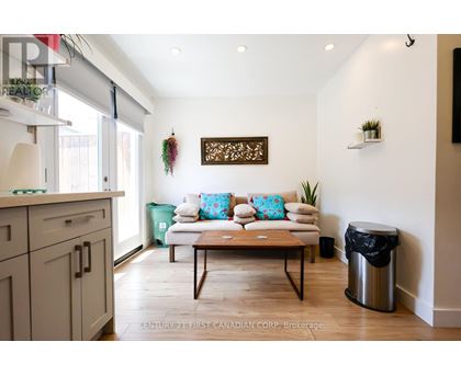 A living room with a couch, a coffee table, and a wall hanging.