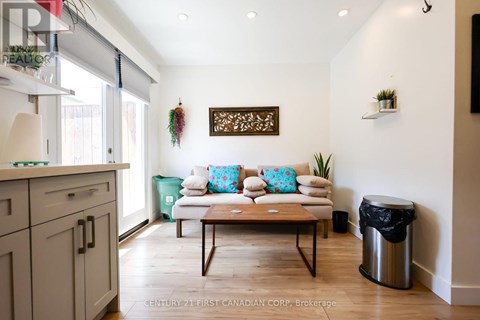 A living room with a couch, a coffee table, and a wall hanging.