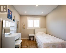 A bedroom with a bed, a dresser, and a window.