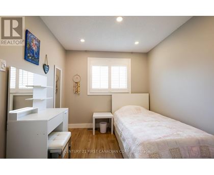 A bedroom with a bed, a dresser, and a window.