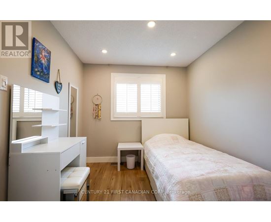 A bedroom with a bed, a dresser, and a window.