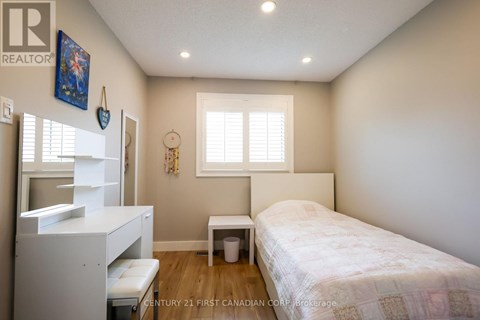 A bedroom with a bed, a dresser, and a window.