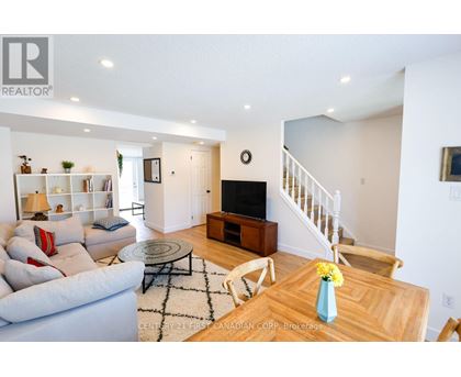 A living room with a couch, a coffee table, and a staircase.