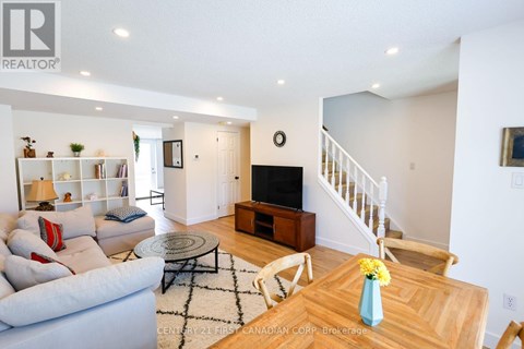 A living room with a couch, a coffee table, and a staircase.