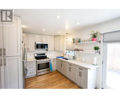 A kitchen with white cabinets and a stainless steel refrigerator.