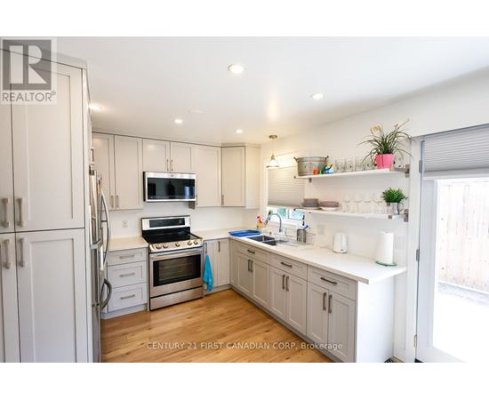 A kitchen with white cabinets and a stainless steel refrigerator.