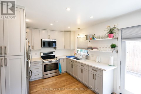 A kitchen with white cabinets and a stainless steel refrigerator.