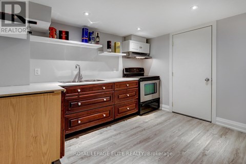 A kitchen with a sink, cabinets, and a microwave.