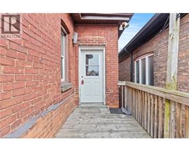 A white door is the centerpiece of a small, red brick building.