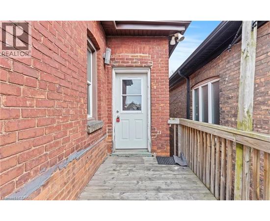 A white door is the centerpiece of a small, red brick building.