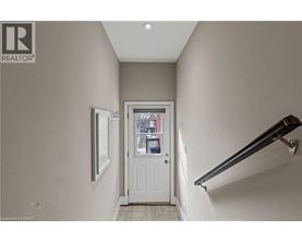 A hallway with a white door and a window.