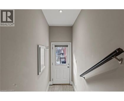 A hallway with a white door and a window.