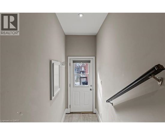 A hallway with a white door and a window.