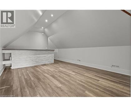 A room with wooden flooring and a stone wall.