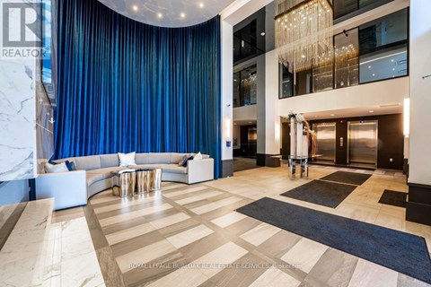 A spacious living room with a curved blue wall and a chandelier.