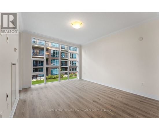 A spacious room with a view of a building across the way.