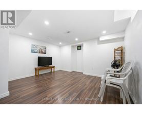 A living room with a wooden floor and white walls.