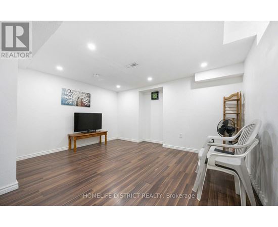 A living room with a wooden floor and white walls.