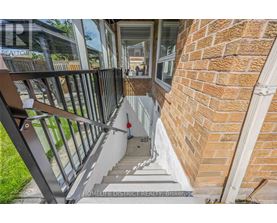 A staircase with a metal railing leads to a glass door.