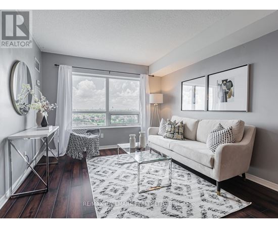 A living room with a white couch and a large window.