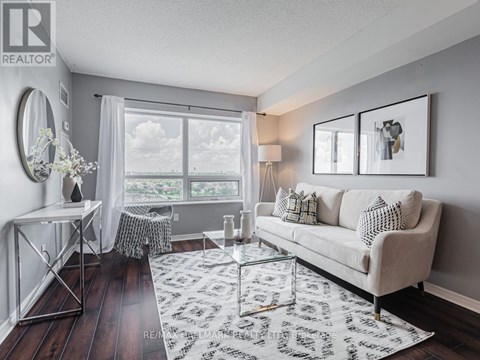 A living room with a white couch and a large window.