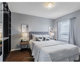 A bedroom with a large bed and a nightstand with a lamp.