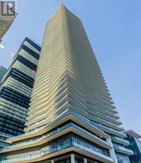 A tall building with a curved facade stands next to a shorter building with a striped pattern.