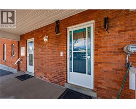 A red brick house with a white door and a sign that says "SOLD".