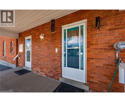 A red brick house with a white door and a sign that says "SOLD".