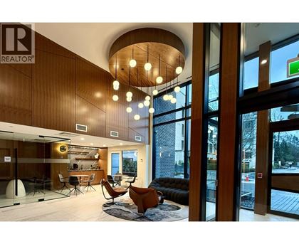 A living room with a couch, chairs, and a rug.