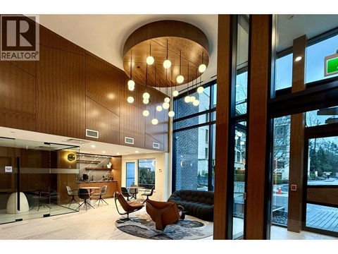 A living room with a couch, chairs, and a rug.