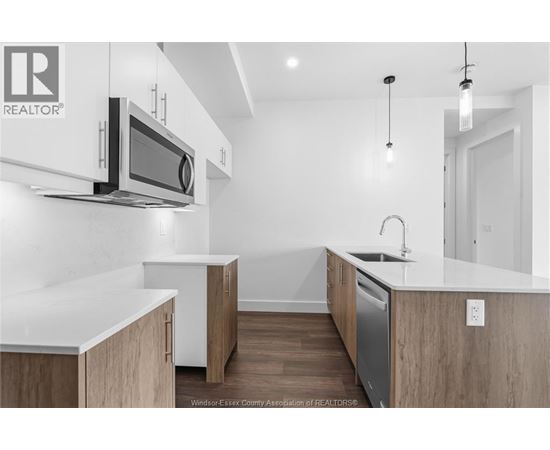 A modern kitchen with wooden cabinets and a white countertop.