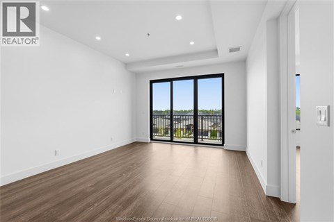 A spacious room with a view of a balcony with a railing.