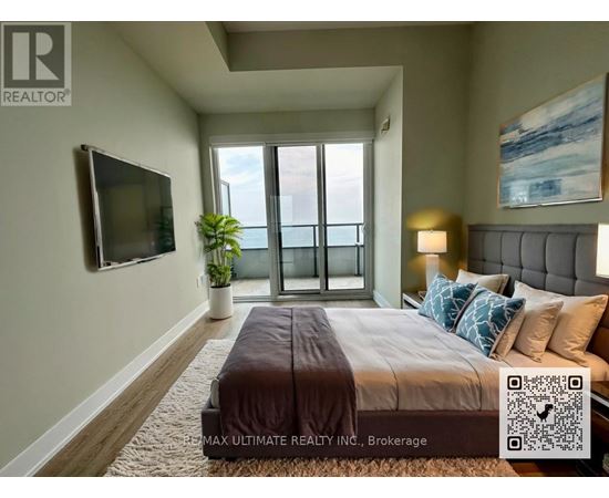 A bedroom with a large bed, a flat screen TV, and a window with a view of the ocean.