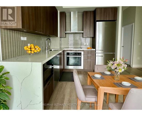 A kitchen with a table and chairs in front of it.