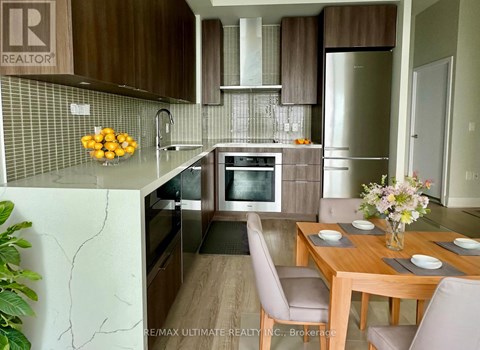 A kitchen with a table and chairs in front of it.