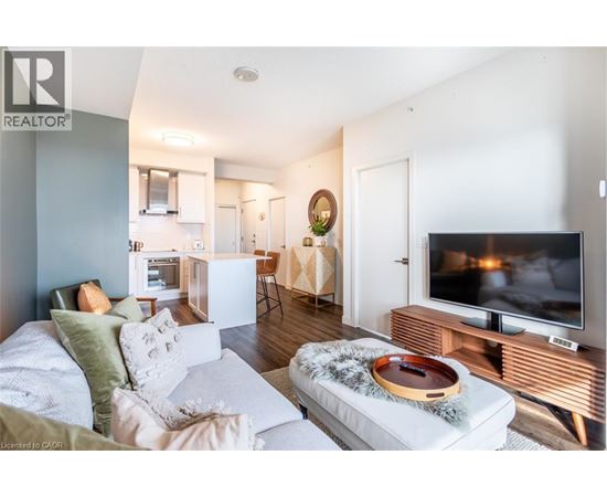 A living room with a white couch and a television on a wooden stand.