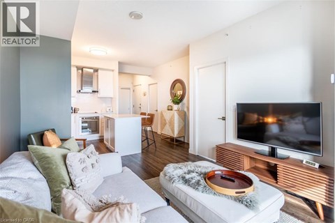 A living room with a white couch and a television on a wooden stand.