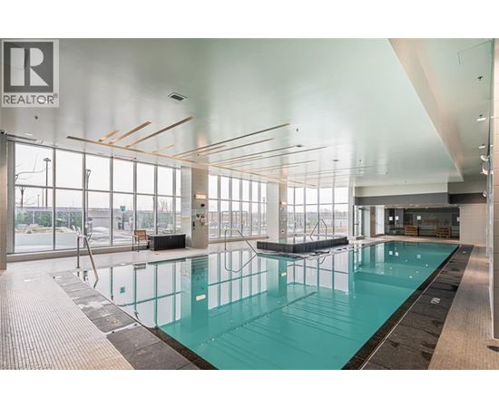 A large indoor swimming pool with a glass wall on one side.
