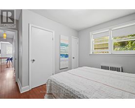 A bedroom with a large bed and a window with blinds.