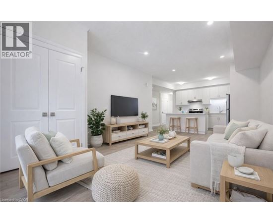 A well-lit living room with a white sofa, a wooden coffee table, and a television.