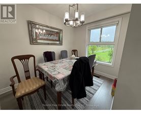 A dining room with a table, chairs, and a window.