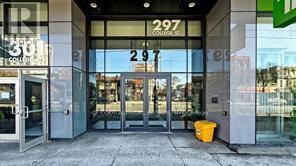 Store front with glass doors and a yellow bucket on the sidewalk.