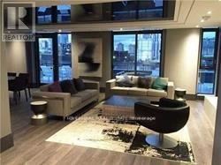 A living room with a couch, a chair, and a coffee table.