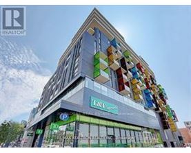 A modern building with a glass facade and a colorful mosaic on the side.