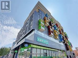 A modern building with a glass facade and a colorful mosaic on the side.