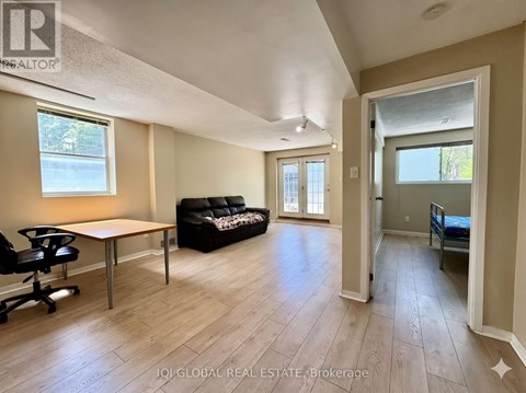 A spacious living room with a black couch and a wooden table.