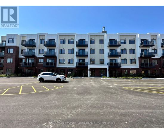 A white car is parked in a parking lot in front of a multi-story apartment building.