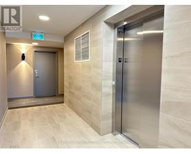 A hallway with a metal elevator and a closed door on the left.